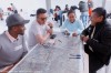 A group of people sit together around a table, annotating maps  thumbnail