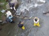 Hub and ASOCAMPO members are seen from above whilst wading in the Cauca River and using a multiparameter probe to take water quality measurements thumbnail