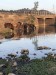 A group of cattle drinking from the riverbank next to a bridge over the polluted Little Akaki River, Ethiopia thumbnail