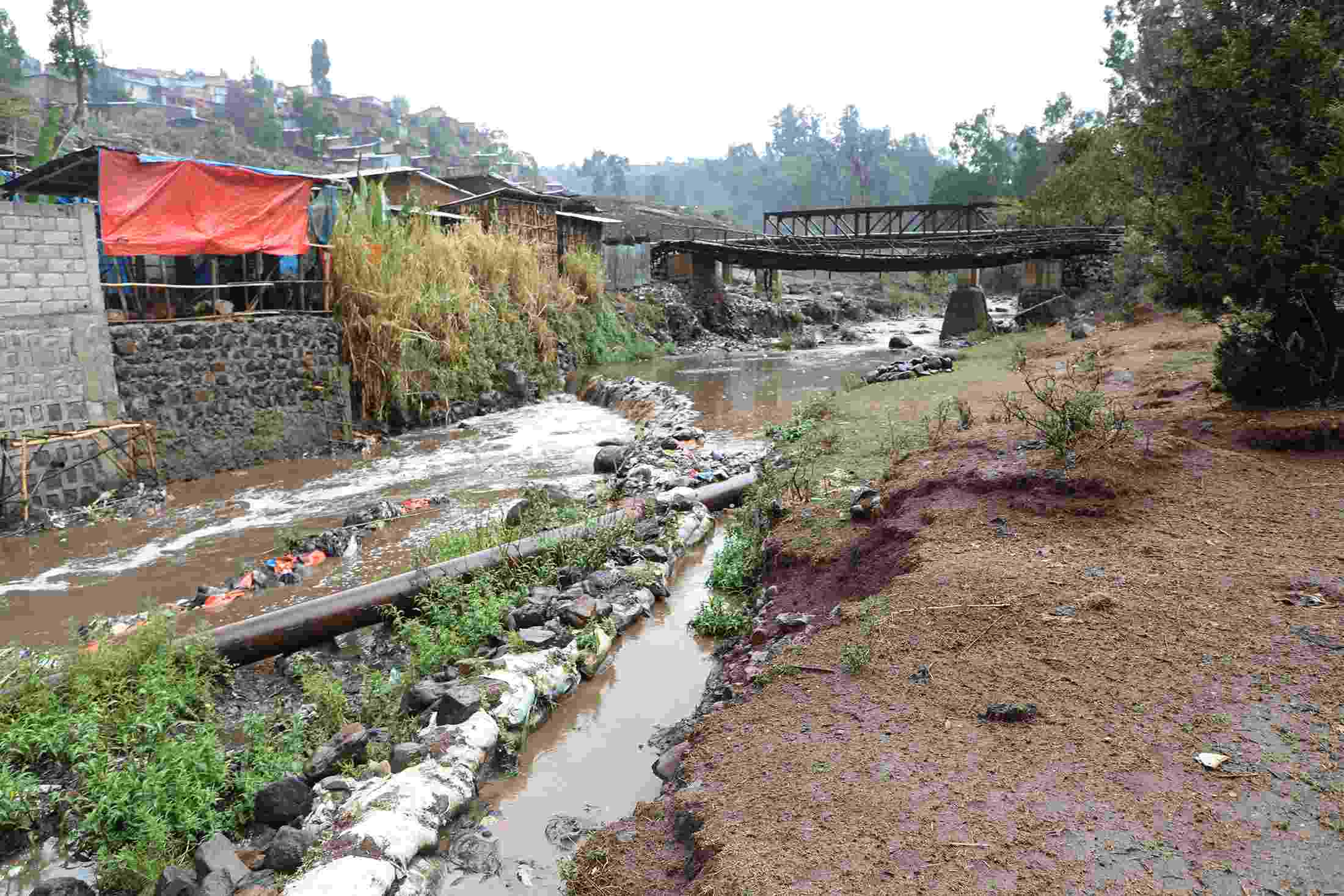 A heavily polluted stretch of the Akaki River, with visible detritus and discoloured water 