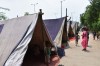People wander past tents at the makeshift relief camp created because of the Yamuna flood in 2019, India thumbnail
