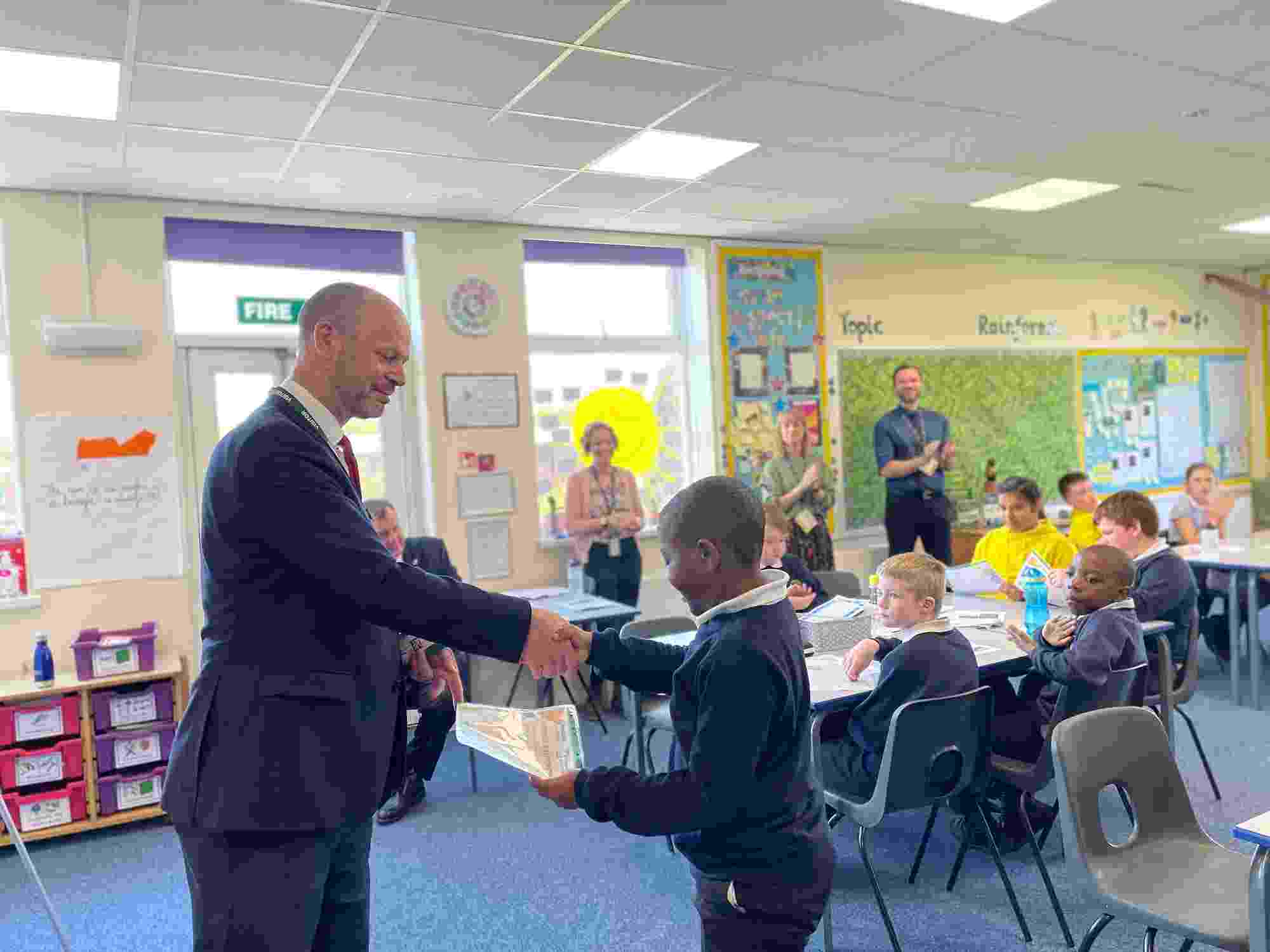 The honourable North of Tyne Mayor, Jamie Driscoll, shakes hands with a primary school student during a certificate presentation