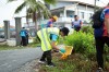 Participants in the World Environment Day event collect rubbish and waste using nets and litter pickers. The gentleman closest to the camera wears a hi-vis tabard and is bent low to the ground whilst retrieving items. thumbnail