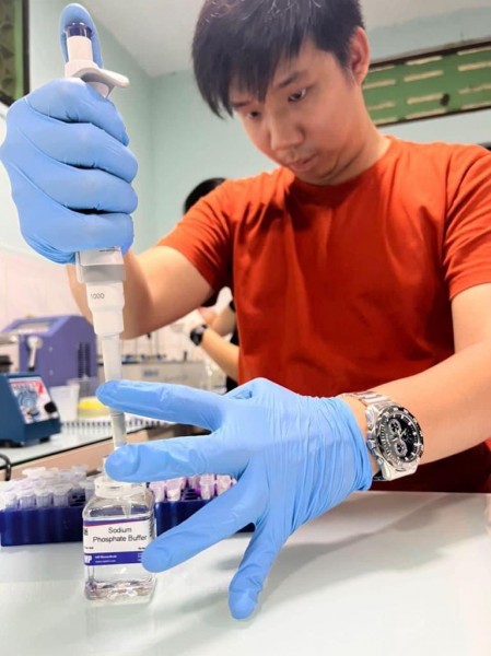 Dominic, the author, uses a pipette to collect sodium phosphate buffer from a bottle