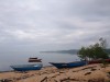 A misty scene on the Johor River in Malaysia, with several boats tethered on the water, and others pulled up onto a sandy bank thumbnail