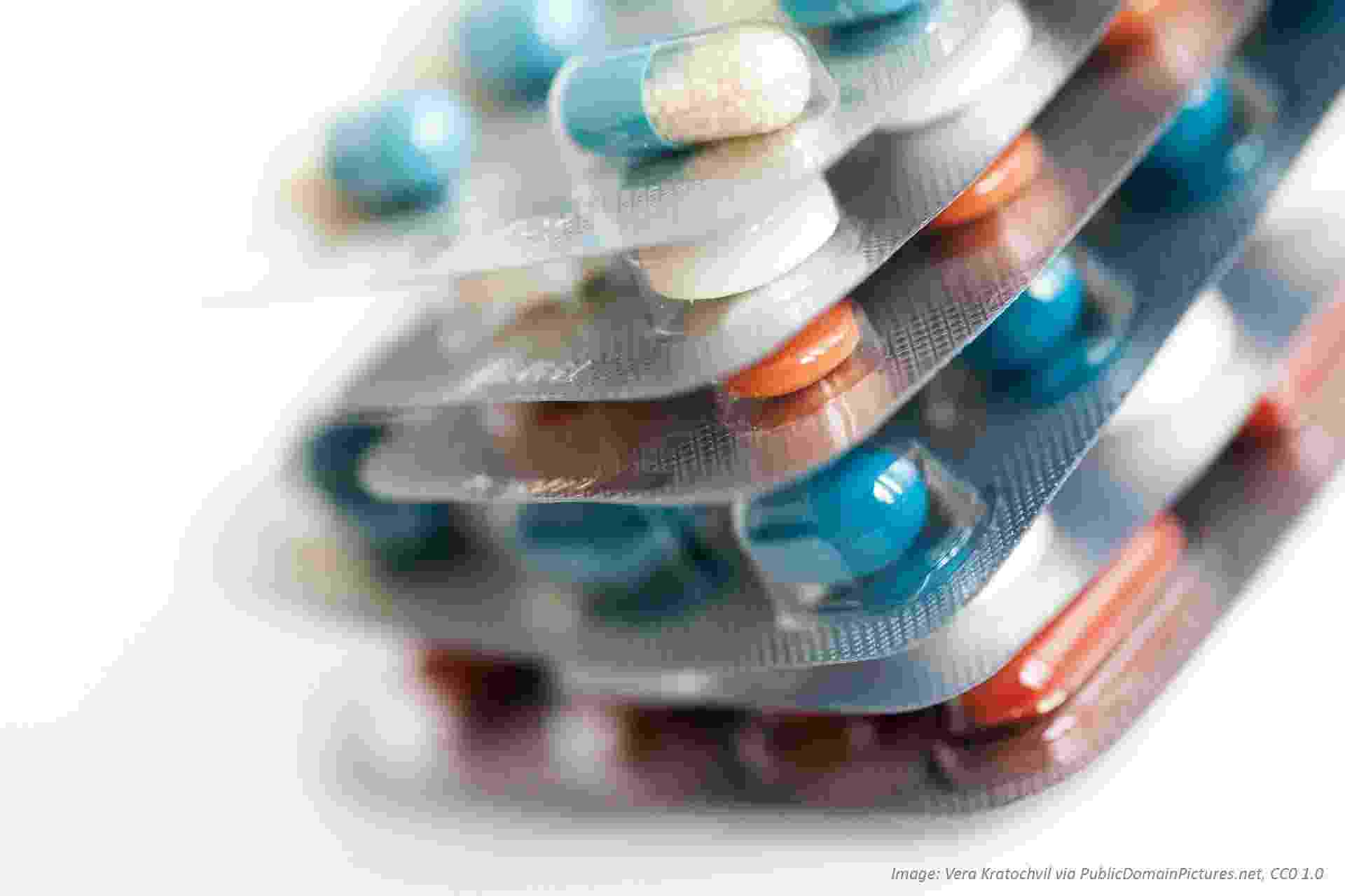 Close up view of foil packets of antibiotic tablets of varying colours, shapes, and sizes
