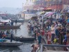 People selling food, washing clothes, bathing, and landing boats around one of the ghats on the banks of the River Ganges, Varanasi, India thumbnail
